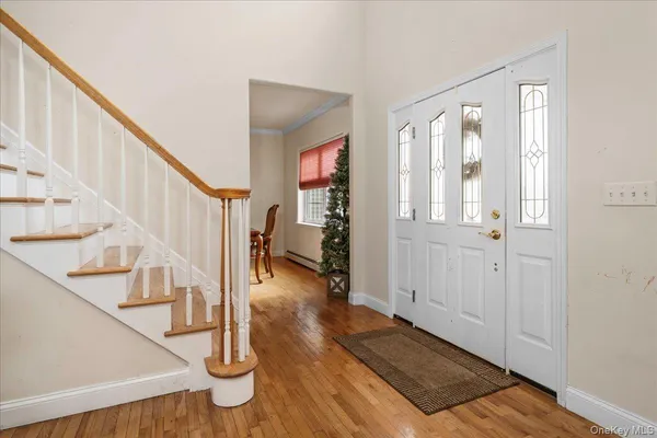 a view of entryway and hall with wooden floor