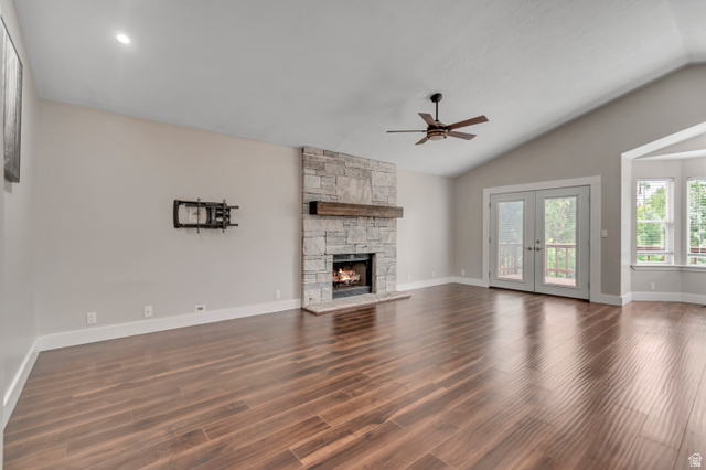 2154 Wasatch Boulevard Sandy, UT 84092 - Photo 19 of 55 Unfurnished living room with a fireplace, dark wood-style flooring, vaulted ceiling, french doors, and ceiling fan