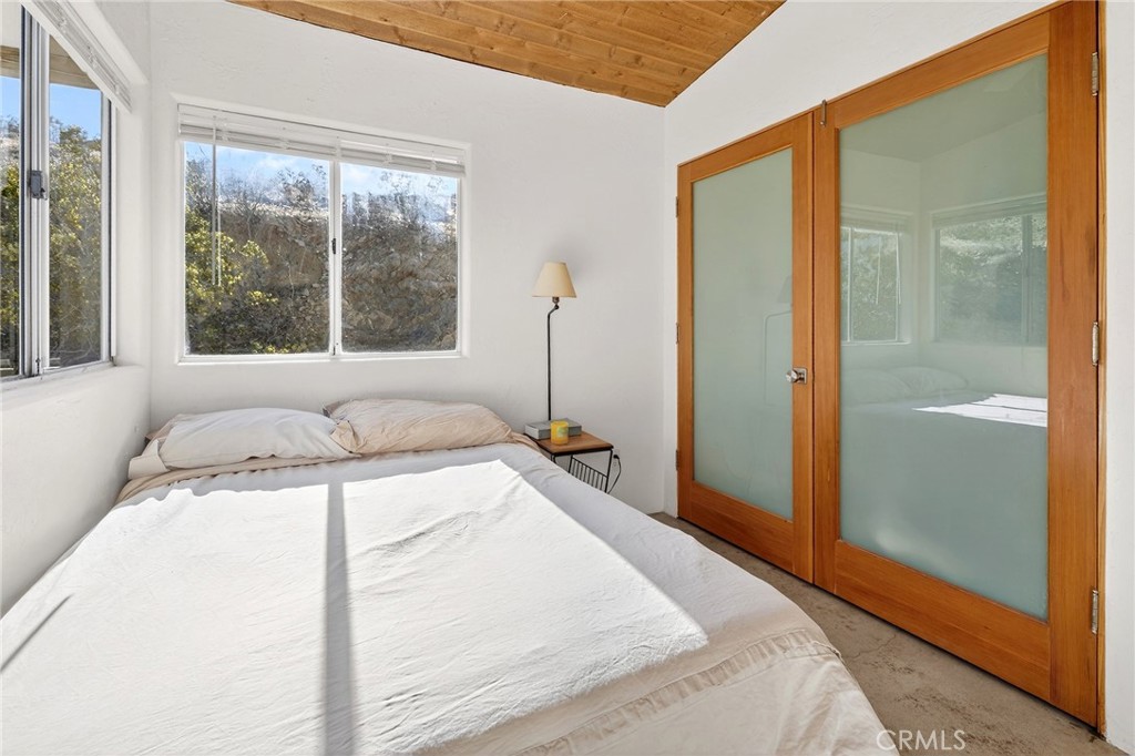 60473 Starlight Road Joshua Tree, CA 92252 - Photo 16 of 39 a spacious bedroom with a bed and a large window