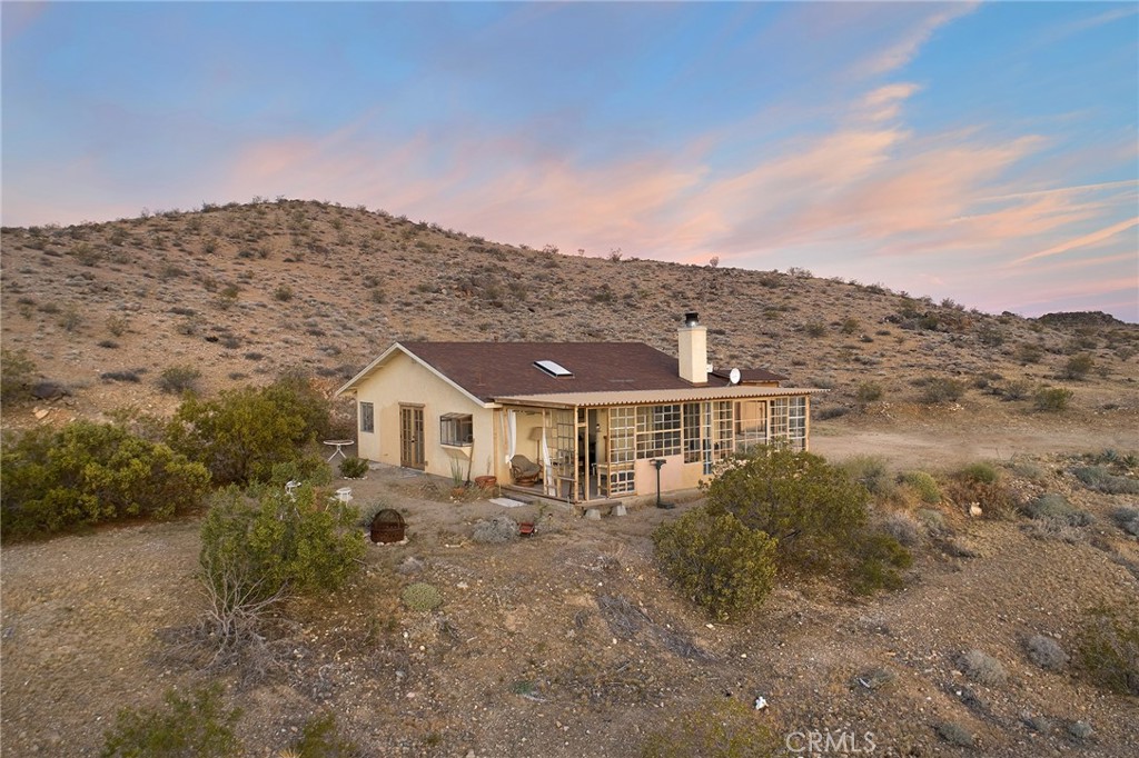 60473 Starlight Road Joshua Tree, CA 92252 - Photo 36 of 39 a view of a big house with a mountain in the background