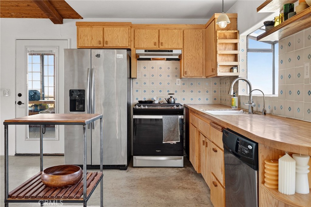 60473 Starlight Road Joshua Tree, CA 92252 - Photo 8 of 39 a kitchen with stainless steel appliances a stove a sink and a refrigerator