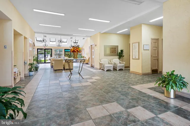a view of a swimming pool with lawn chairs and a dining table under an umbrella