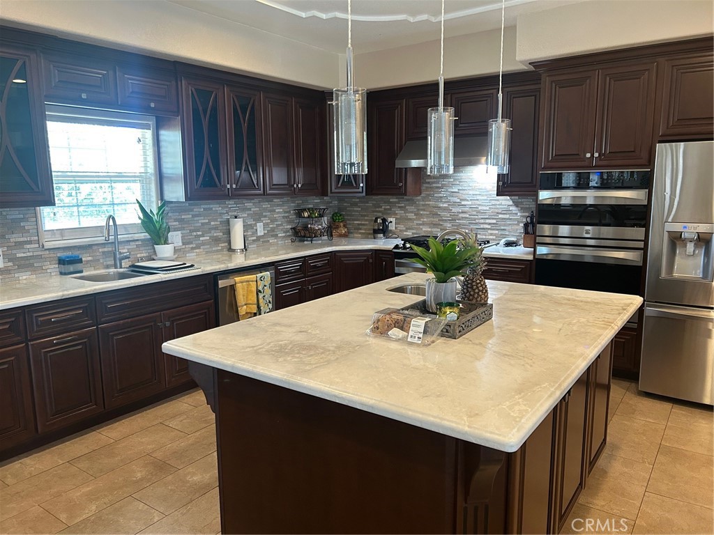 5995 West Brooks Road Merced, CA 95341 - Photo 3 of 20 a kitchen with a sink a kitchen island and stainless steel appliances