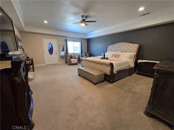 a spacious bedroom with a bed and a chandelier