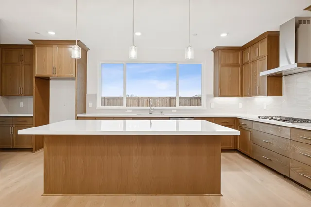 a kitchen with stainless steel appliances granite countertop a sink a stove and a refrigerator