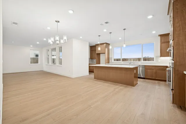 a large white kitchen with kitchen island a sink a stove and a refrigerator