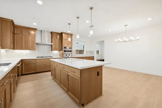 a kitchen with a stove a sink a kitchen island with wooden cabinets