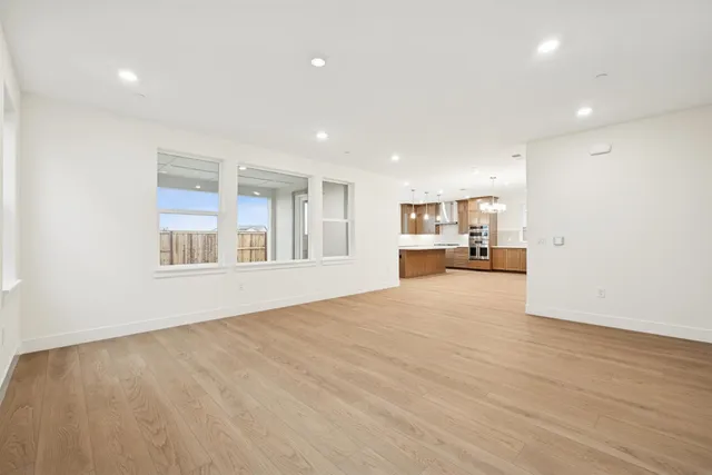 a view of empty room with a kitchen