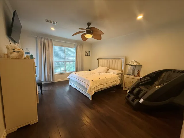a bedroom with a bed and a flat tv screen on dresser