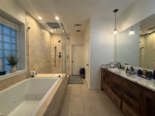 a spacious bathroom with a tub sink shower and mirror