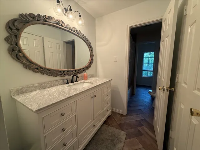 a bathroom with a granite countertop sink and a mirror