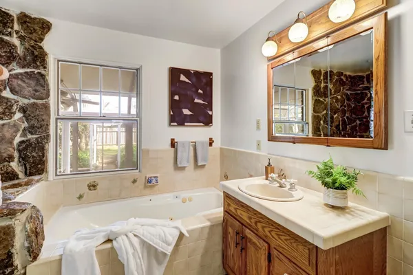a bedroom with a bed a chandelier and dresser