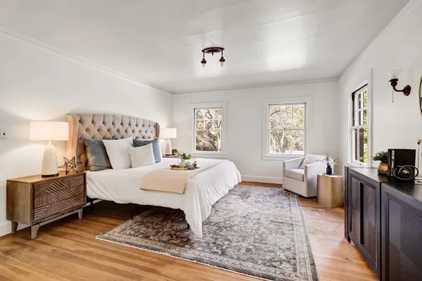 a bedroom with a bed a mirror and a window