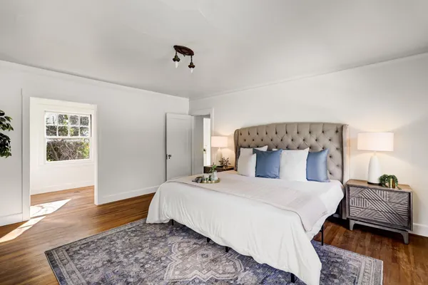 a bedroom with a bed and wooden floor