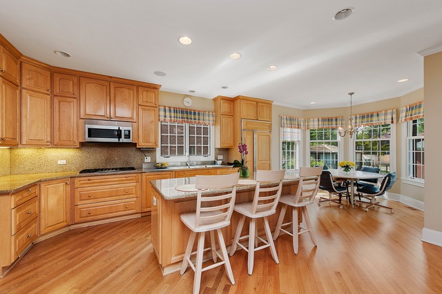 330 Greenleaf Avenue Wilmette, IL 60091 - Photo 7 of 23 a kitchen with stainless steel appliances granite countertop a stove top oven a dining table and chairs with wooden floor