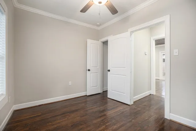 an empty room with wooden floor and chandelier fan