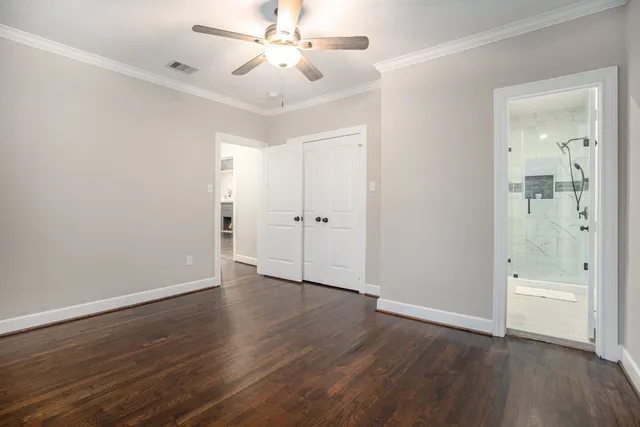 an empty room with wooden floor and a ceiling fan