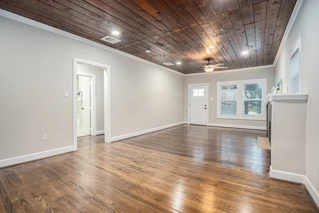 a view of empty room with wooden floor and windows
