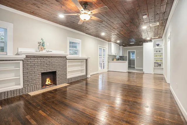 a living room with stainless steel appliances kitchen island granite countertop furniture and a fireplace