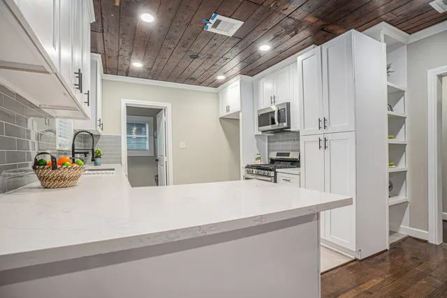 a kitchen with kitchen island a counter and a refrigerator