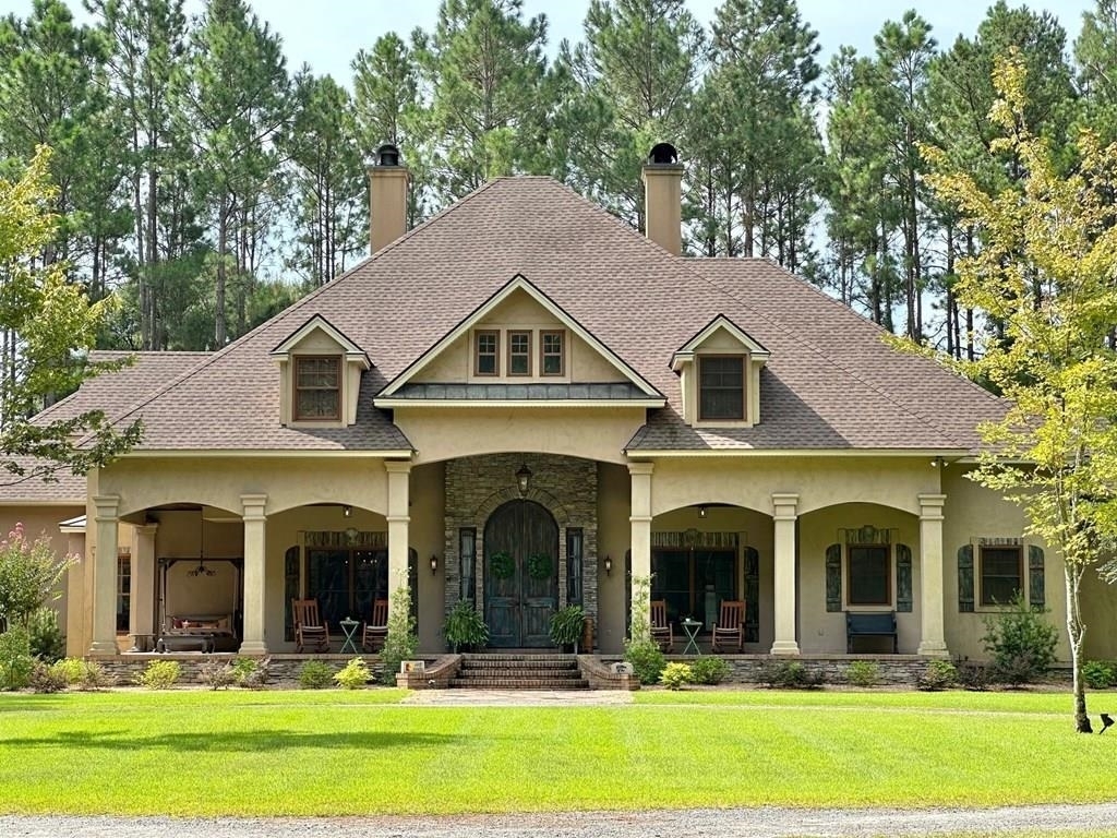 a view of a house with swimming pool and chairs