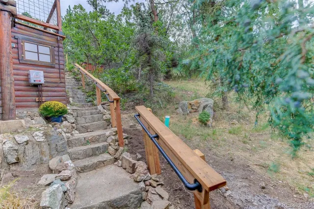 a view of an empty room with wooden floor fireplace and a window