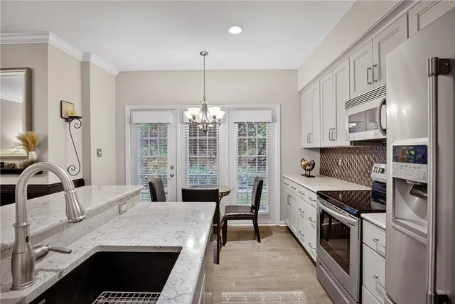 a kitchen with stainless steel appliances kitchen island granite countertop a sink stove and refrigerator