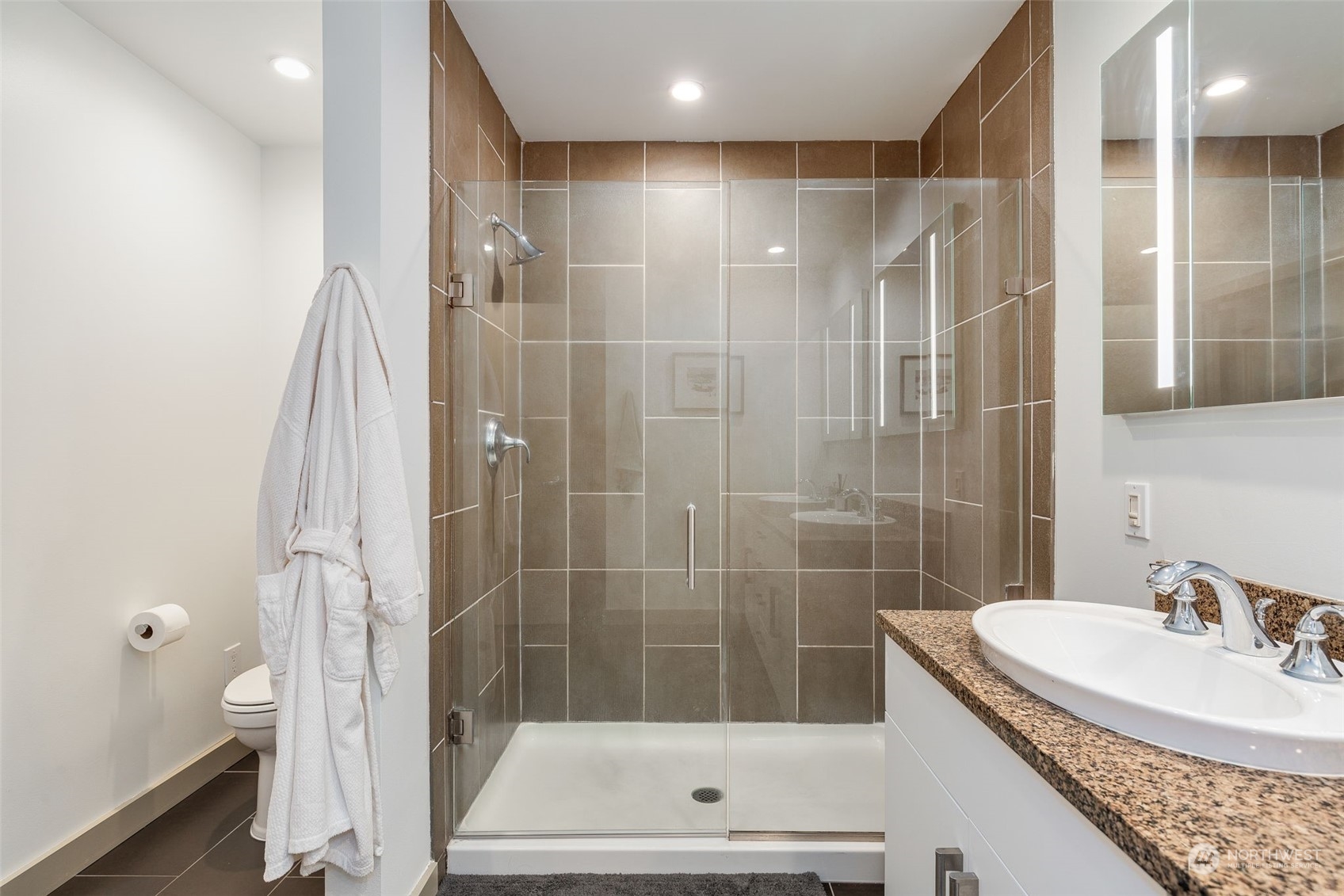 910 Lenora Street, Unit S310 Seattle, WA 98121 - Photo 26 of 40 a bathroom with a granite countertop sink a shower and a mirror