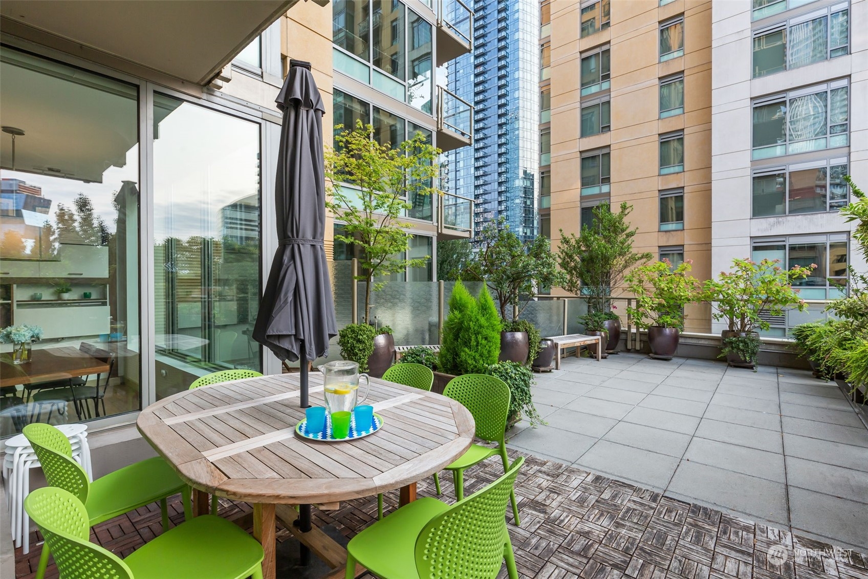 910 Lenora Street, Unit S310 Seattle, WA 98121 - Photo 7 of 40 a view of a patio with a table and chairs potted plants with wooden floor and outdoor seating