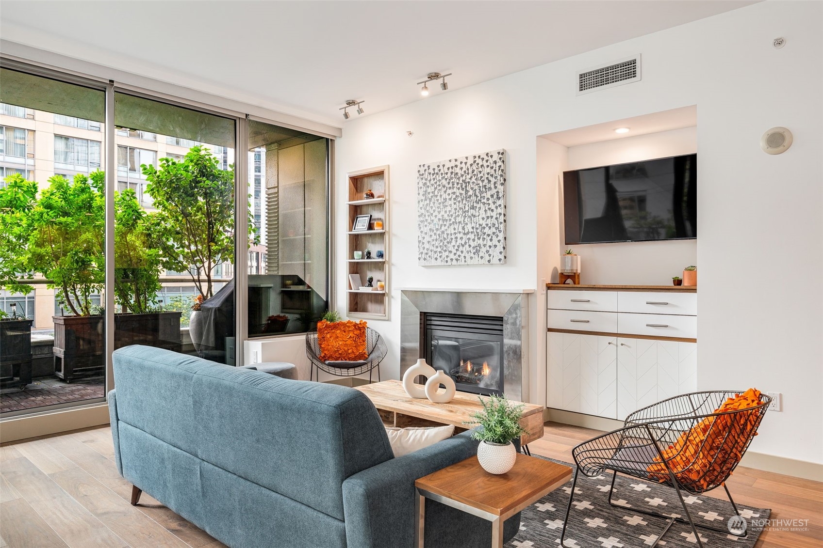 910 Lenora Street, Unit S310 Seattle, WA 98121 - Photo 10 of 40 a living room with furniture a flat screen tv and a fireplace