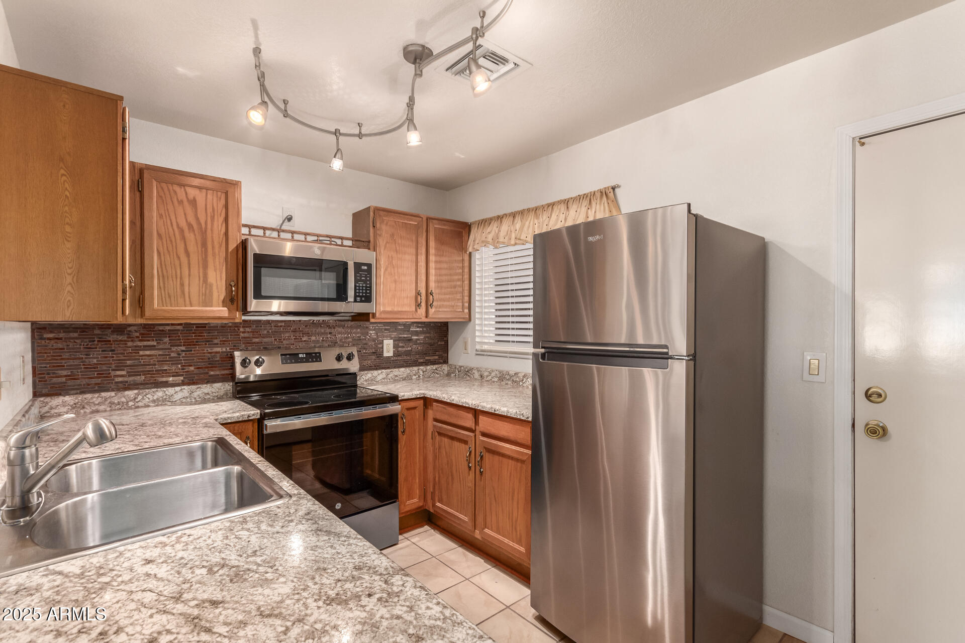 5808 East Brown Road, Unit 119 Mesa, AZ 85205 - Photo 6 of 12 a kitchen with a refrigerator sink and microwave
