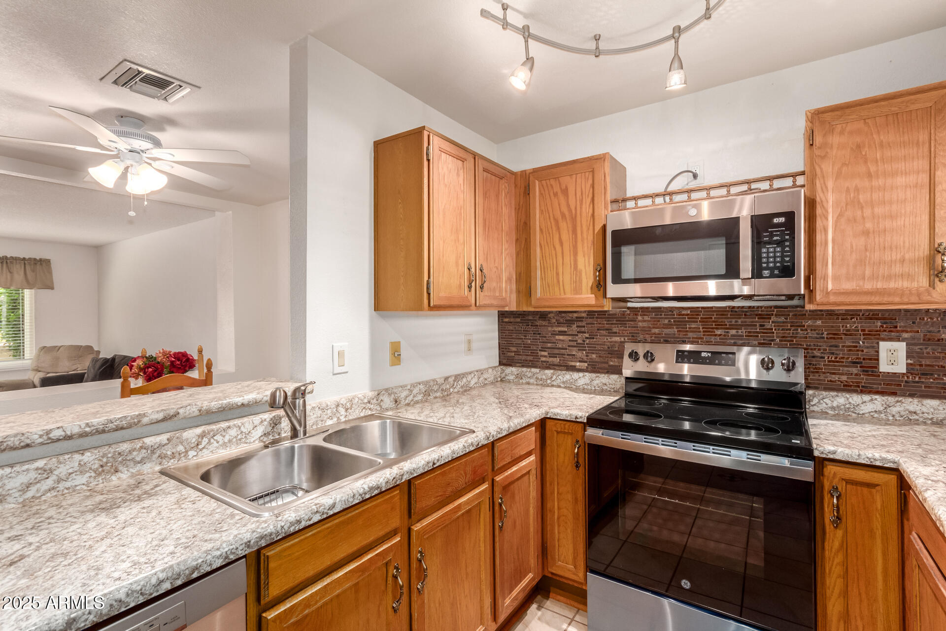5808 East Brown Road, Unit 119 Mesa, AZ 85205 - Photo 7 of 12 a kitchen with stainless steel appliances granite countertop a sink a stove microwave and cabinets