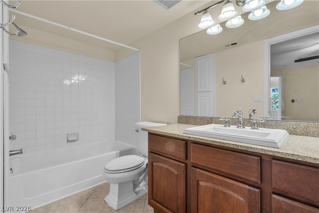 8101 West Flamingo Road, Unit 2001 Las Vegas, NV 89147 - Photo 9 of 28 An inviting bathroom offers a spacious bathtub, a classic toilet, and a vanity with a large mirror.