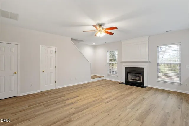 an empty room with windows fireplace and a sink