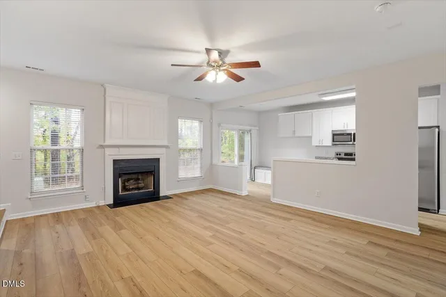 a view of empty room with wooden floor and fireplace