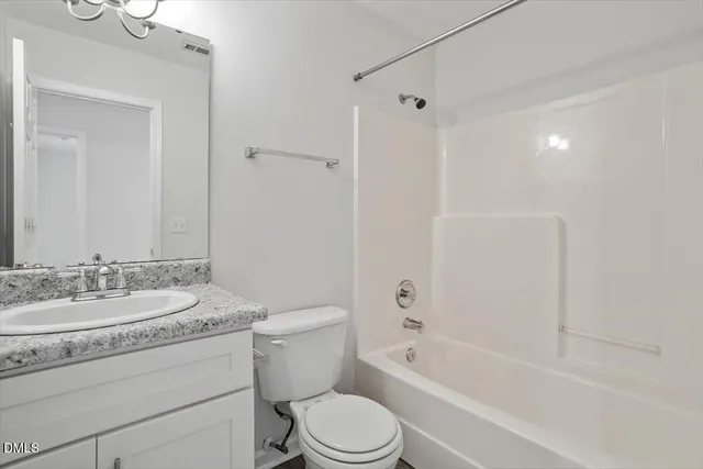 a bathroom with a granite countertop toilet a sink and a bathtub