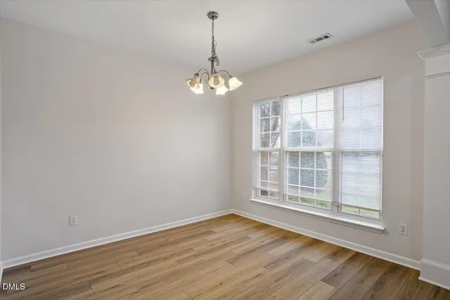 a view of wooden floor and a chandelier in a room