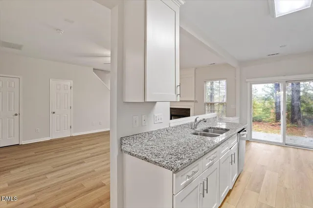 a kitchen with granite countertop kitchen island wooden floors and white cabinets