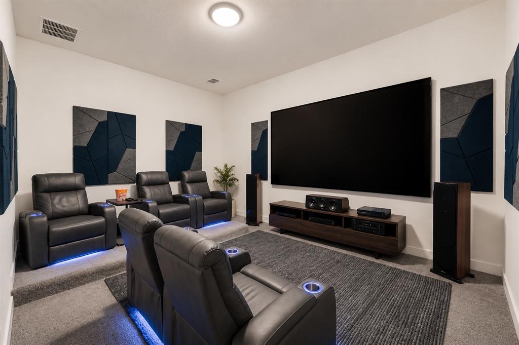 2150 Charming Frg Road Forney, TX 75126 - Photo 19 of 40 Dedicated media room featuring a large projection screen, integrated wall sound panels, and multi-level carpeted flooring