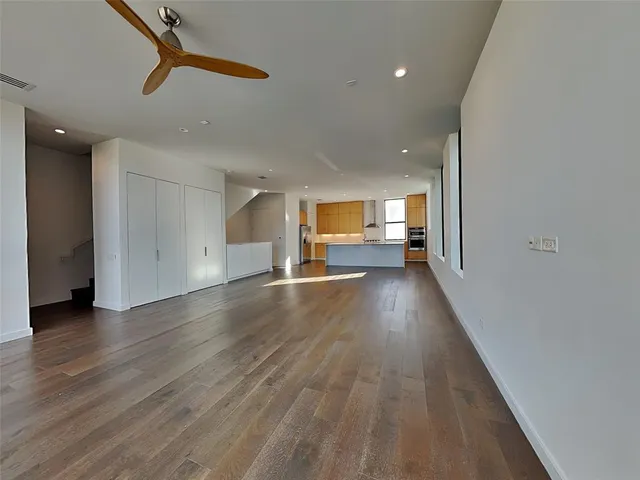 a view of empty room with wooden floor