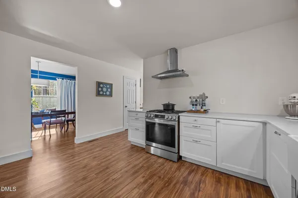 a kitchen with granite countertop a stove and a wooden floors