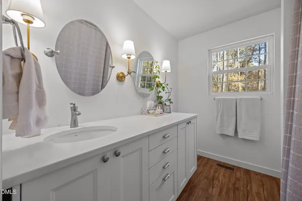a bathroom with a double vanity sink and a mirror