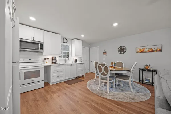 a kitchen with a dining table chairs and refrigerator