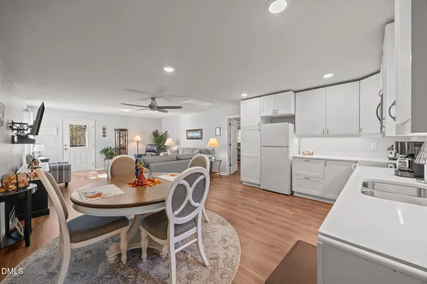 a kitchen with a dining table chairs and refrigerator