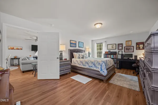 a bedroom with a bed and furniture with wooden floor
