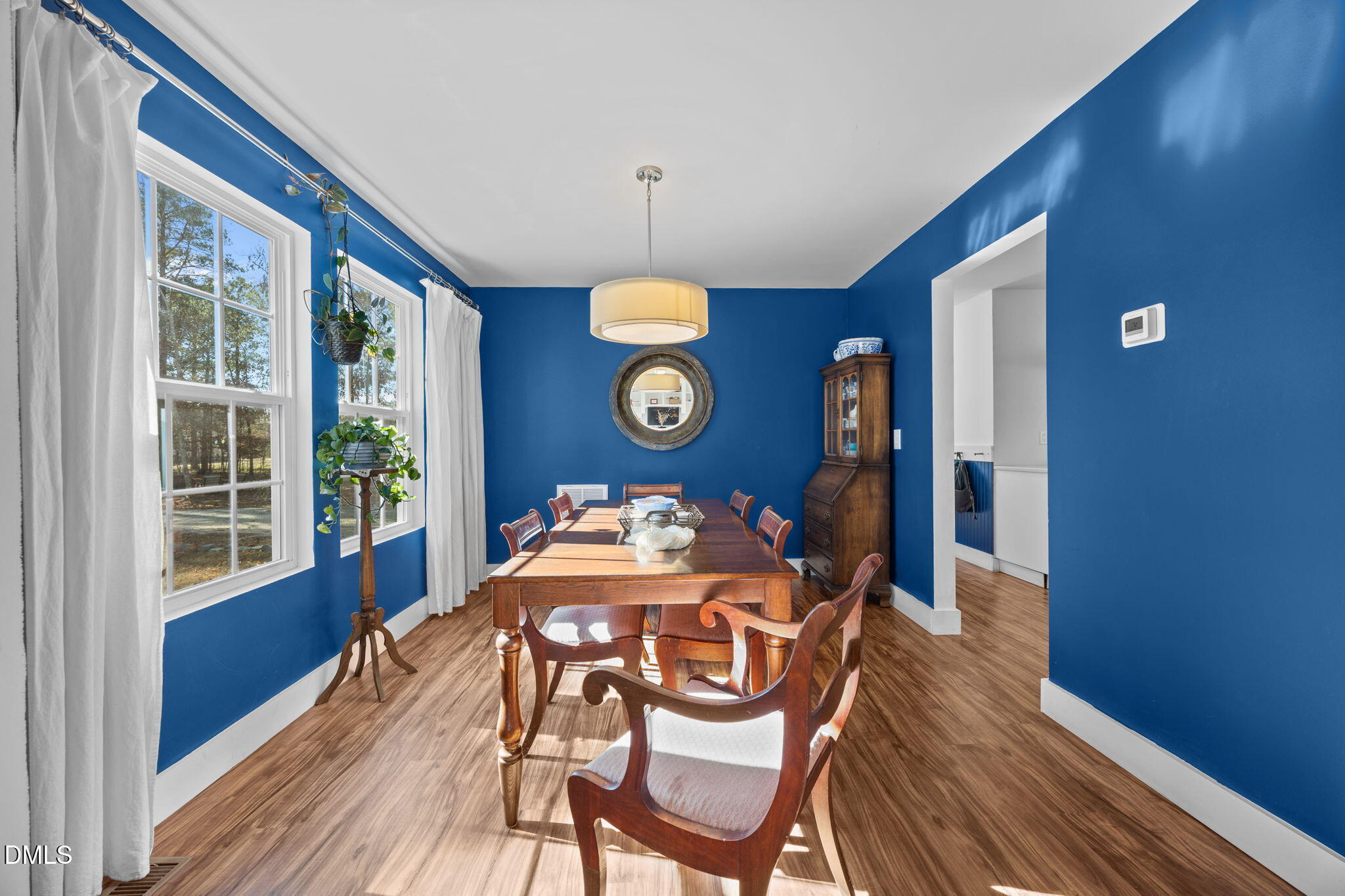 499 Jumping Run Road Dunn, NC 28334 - Photo 7 of 42 a dining room with wooden floor a chandelier a wooden table and chairs