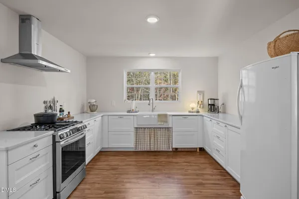 a kitchen with white cabinets and white appliances