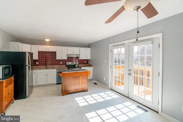 a kitchen with stainless steel appliances granite countertop a refrigerator and a stove top oven
