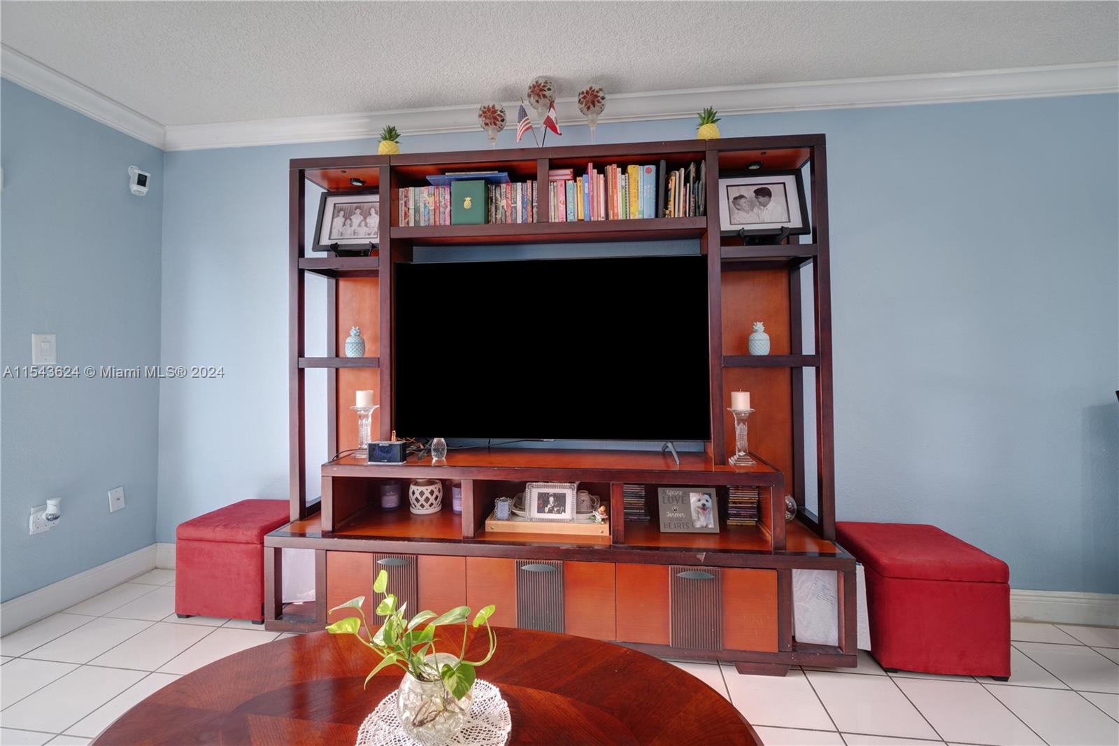 a living room with furniture bookshelf and a flat screen tv
