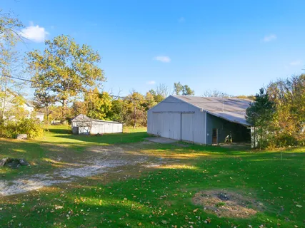 a white house with a big yard and large trees